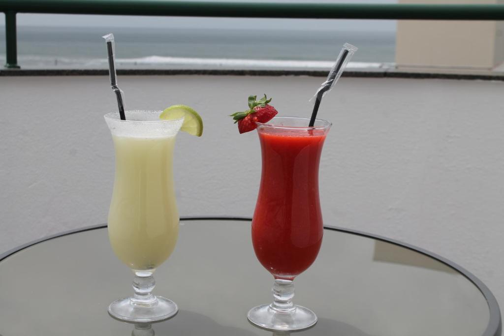 two cocktails sitting on a glass table at Real Caparica Hotel in Costa da Caparica