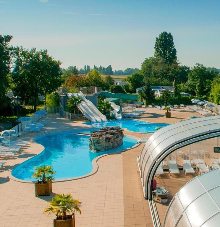 a large swimming pool with a slide in a resort at Mareva37 in Trogues