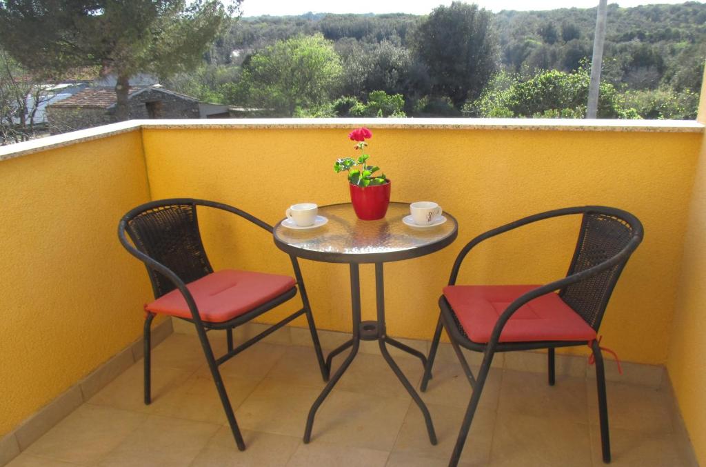 - Balcón con mesa pequeña y 2 sillas en Apartman Bukaleta in Loznati, en Loznati