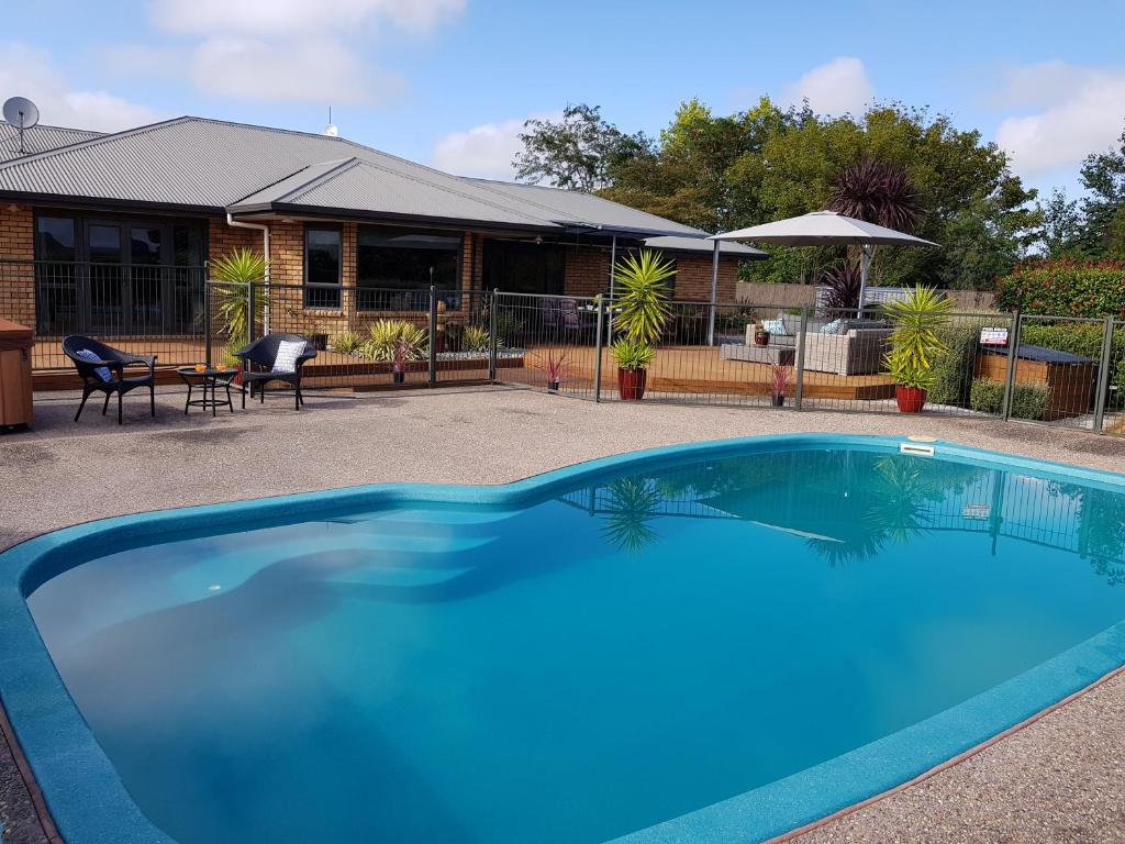 a large blue swimming pool in front of a house at Applecross Sanctuary in Cambridge