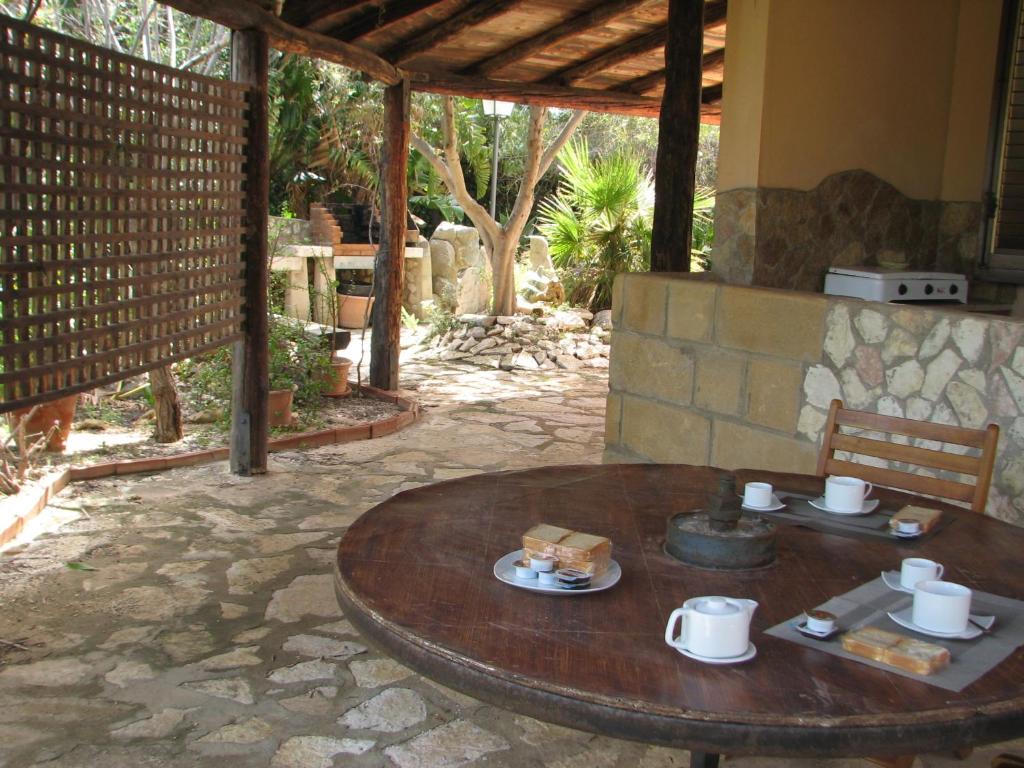 a wooden table with food on top of a patio at Silva Garden in San Vito lo Capo