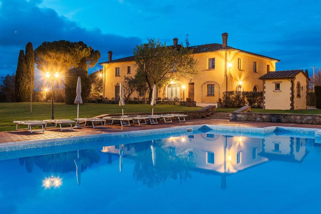 a villa with a swimming pool at night at Villa Aia Vecchia in Bibbona