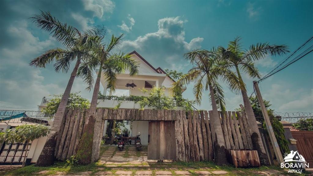 a house with palm trees in front of it at Boravin House in Siem Reap