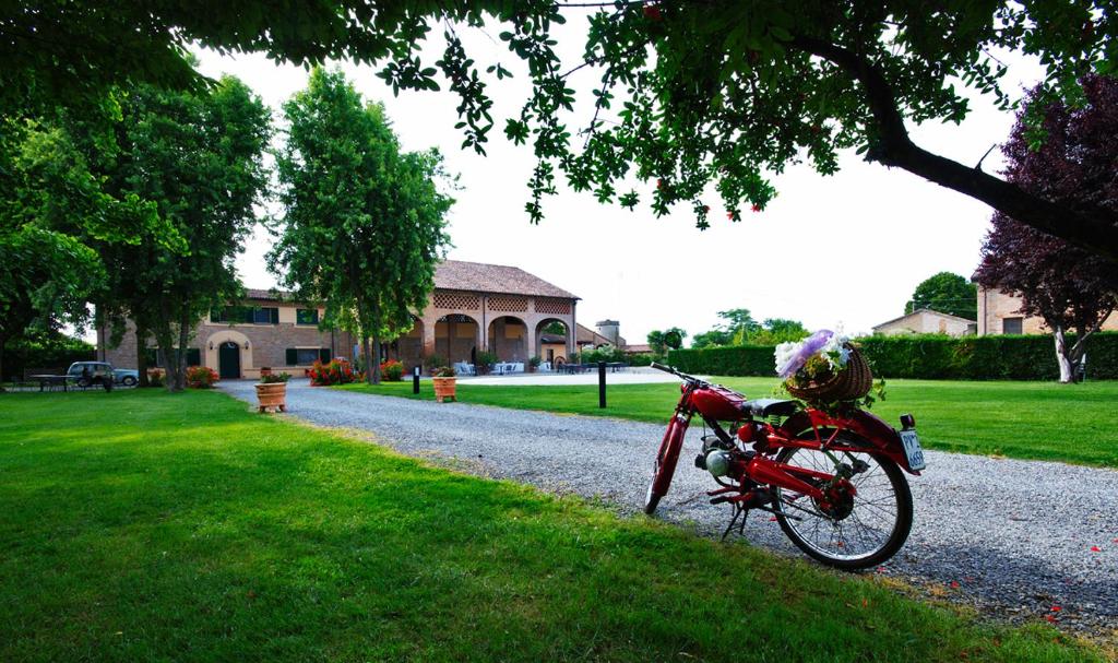 una bici rossa parcheggiata sul ciglio di una strada sterrata di Agriturismo Tenuta Casteldardo a Besenzone