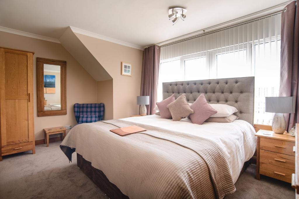 um quarto com uma cama grande e uma janela em Jannel Bed & Breakfast em Stornoway