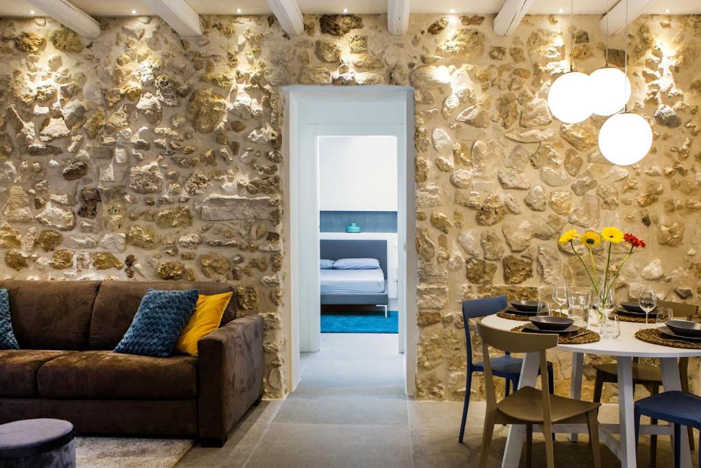 ein Wohnzimmer mit einem Sofa und einem Tisch in der Unterkunft Residenza Nereo in Syrakus