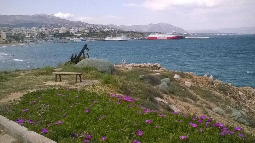 a bench sitting on top of a hill next to the water at Nireos Proteos 20 in Rafina