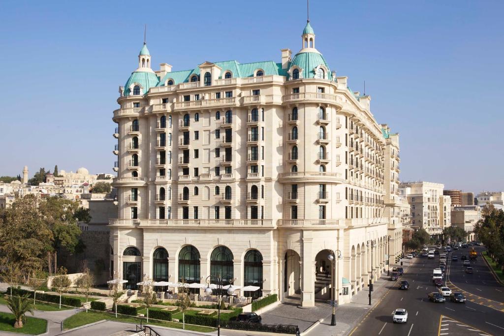 duży biały budynek po stronie ulicy w obiekcie Four Seasons Hotel Baku w mieście Baku