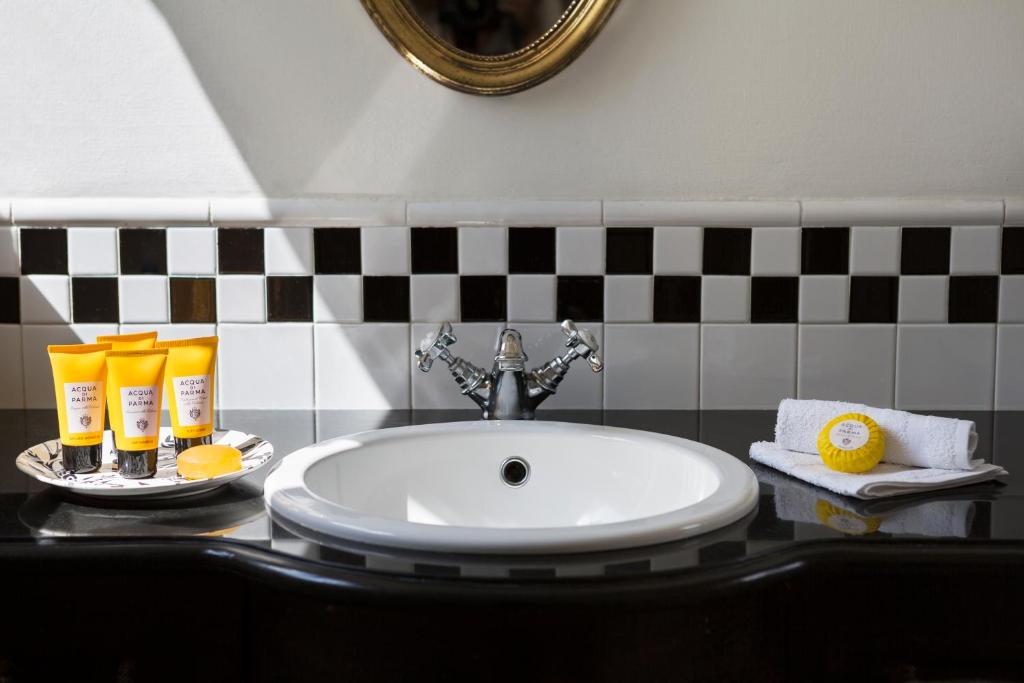 a bathroom sink with a plate of orange juice and a sink at The American Colony Hotel - Small Luxury Hotels of the World in Jerusalem