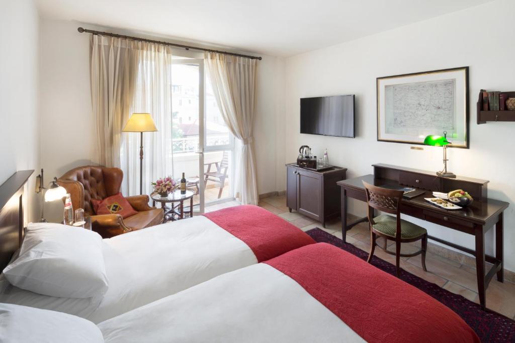a hotel room with a bed and a desk at The American Colony Hotel - Small Luxury Hotels of the World in Jerusalem