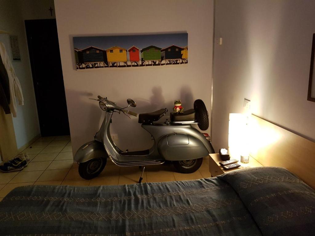 a silver scooter parked in a room with a bed at Il Chiesino in Pontedera