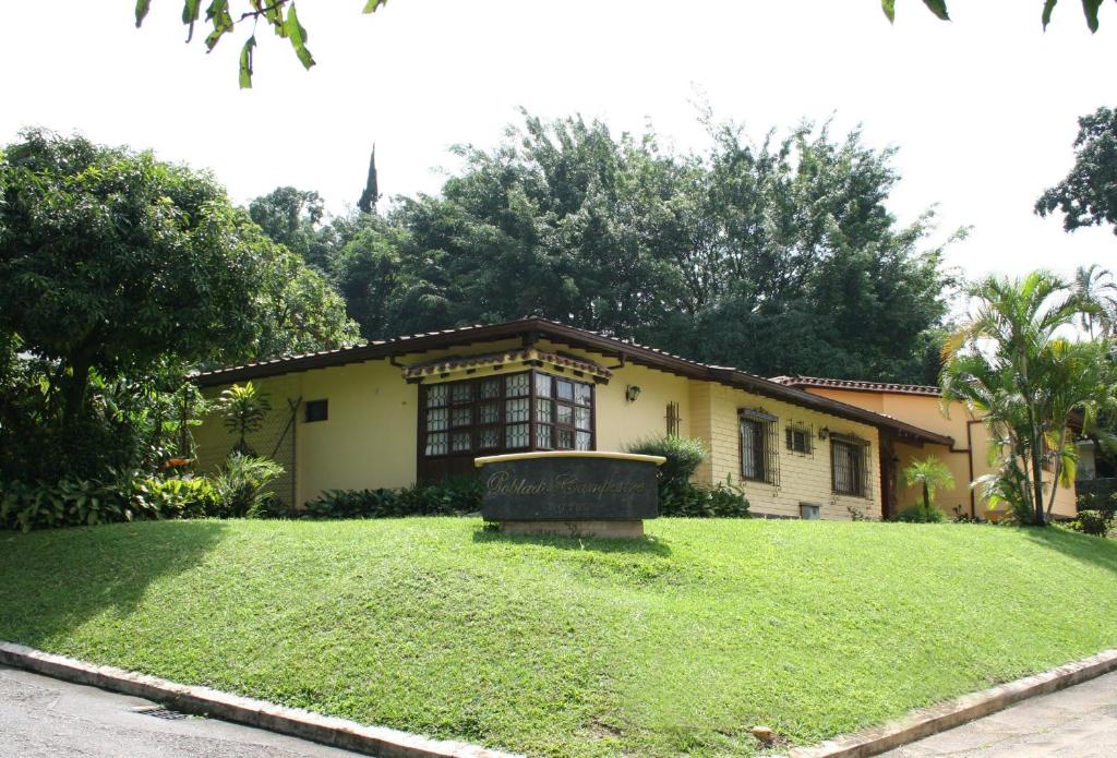 dom z dużym trawnikiem przed nim w obiekcie Hotel Poblado Campestre w mieście Medellín