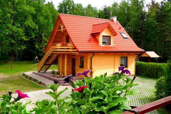 una pequeña casa con techo rojo en un patio en Agroturystyka "Pod Łysicą", en Święta Katarzyna