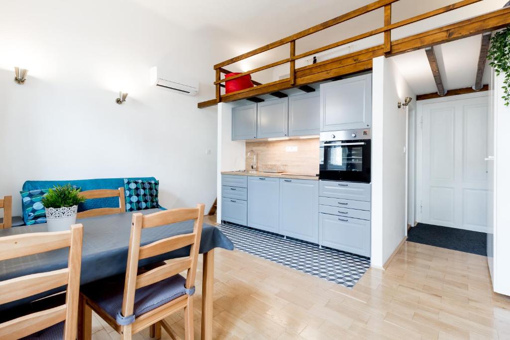 a kitchen and dining room with white cabinets and a table at Flexible SelfCheckIns 13 & 14 - Le Petit & Le Grand Zagreb - Centre - New - Apartments Repinc in Zagreb