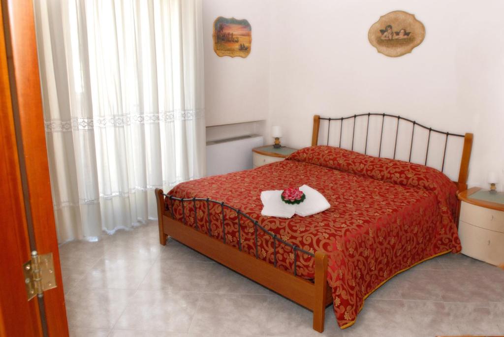 a bedroom with a red bed with a tray of flowers on it at Mare And City House in Manfredonia