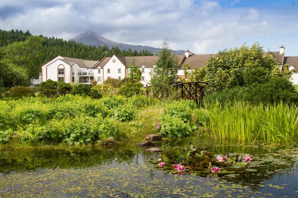 a garden with flowers in the water in front of a house at Auchrannie Resort in Brodick