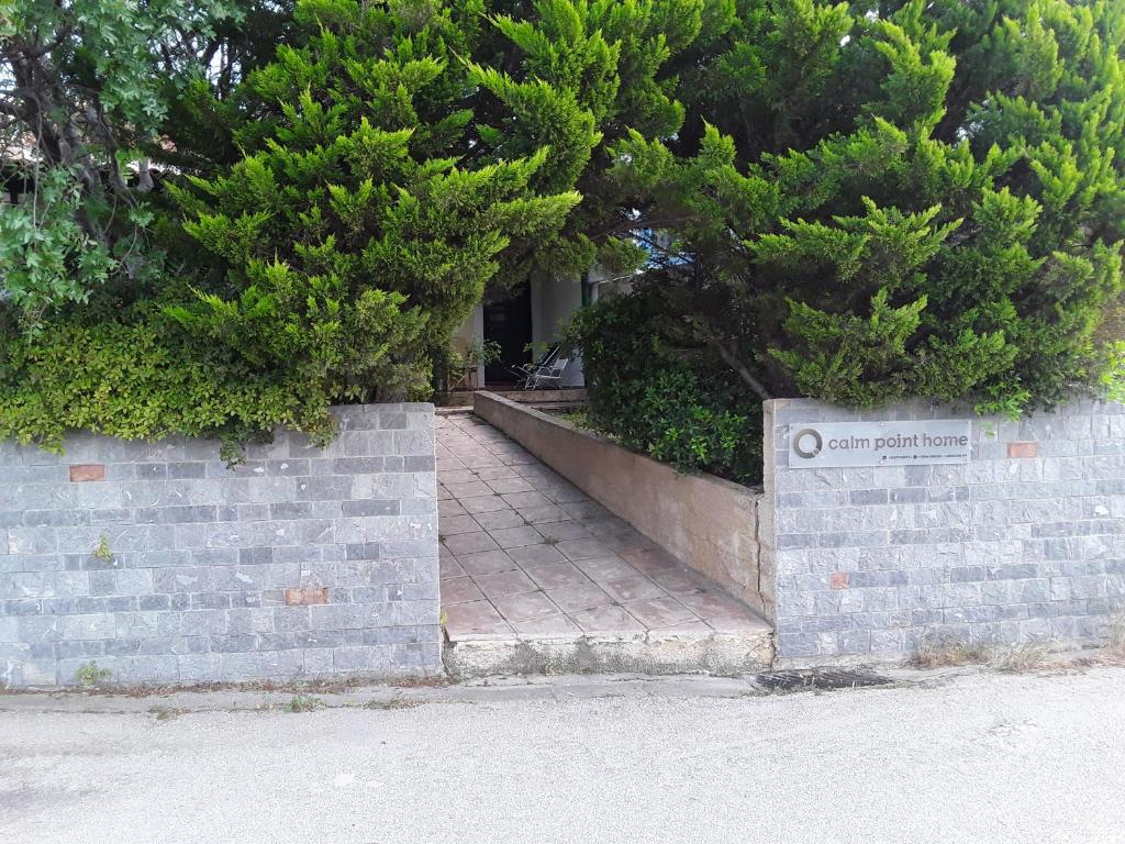 a brick retaining wall with a sign on it at Calm Point Home in Volissos
