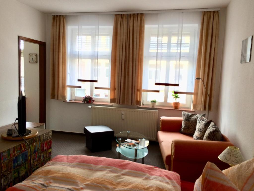 - un salon avec un canapé et 2 fenêtres dans l'établissement Ferienwohnung Lilly, à Wittenberge