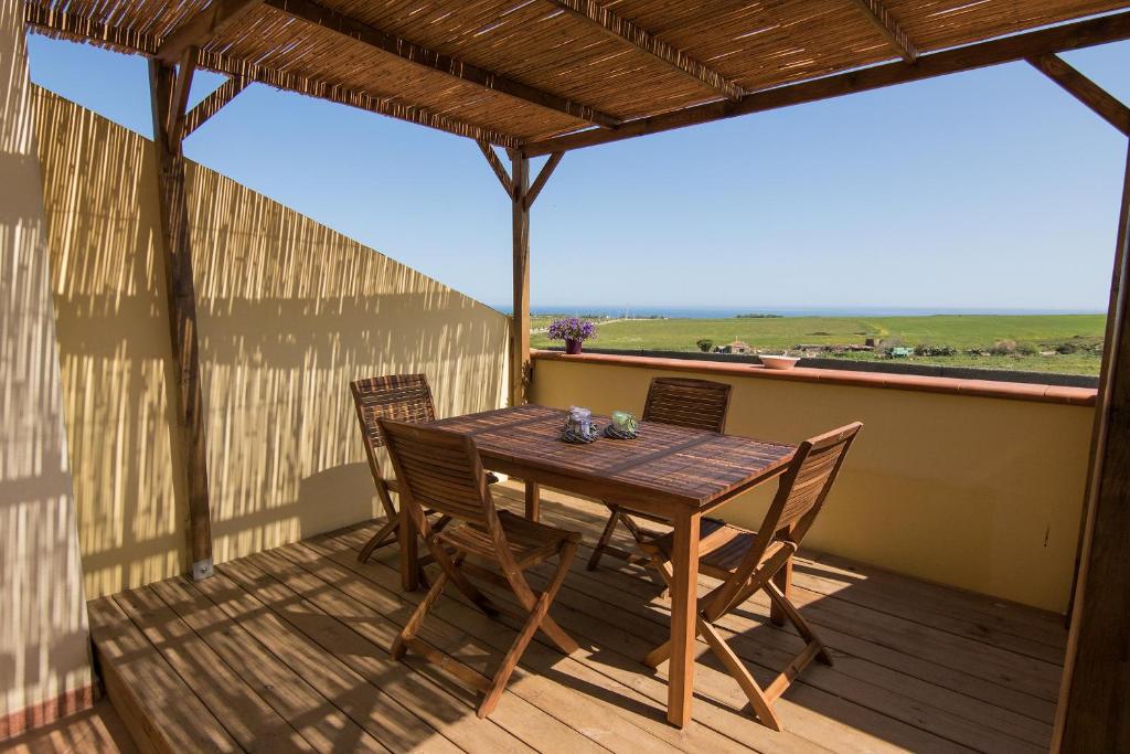 een houten tafel en stoelen op een terras met uitzicht bij Casa Madì in Porto Torres