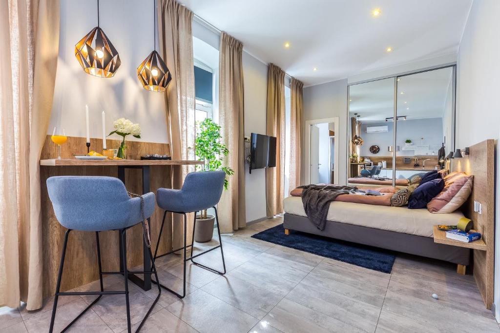 um quarto com uma cama, uma mesa e cadeiras em Number 1 Deluxe Apartments em Rijeka