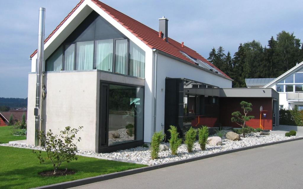 ein weißes Haus mit rotem Dach in der Unterkunft Panorama-Übernachtungen in Biberach-Ummendorf