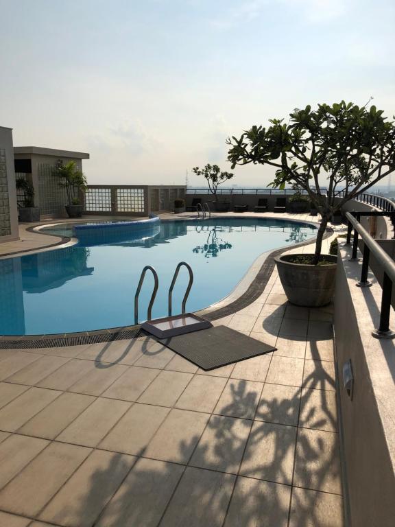 a swimming pool with a tree on a building at Hedges Court Residencies -Town Hall- 2 Room 3 Bed Apartment in Colombo