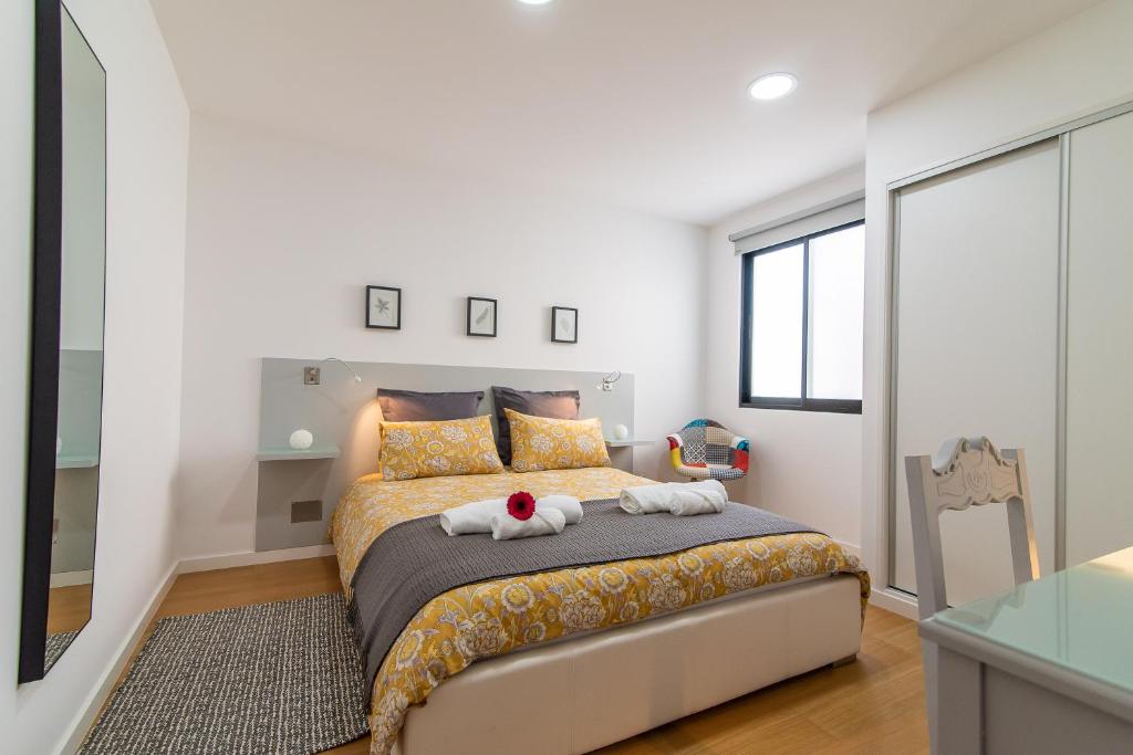 een slaapkamer met een bed met twee handdoeken erop bij Chez Lúcia in Ponta Delgada