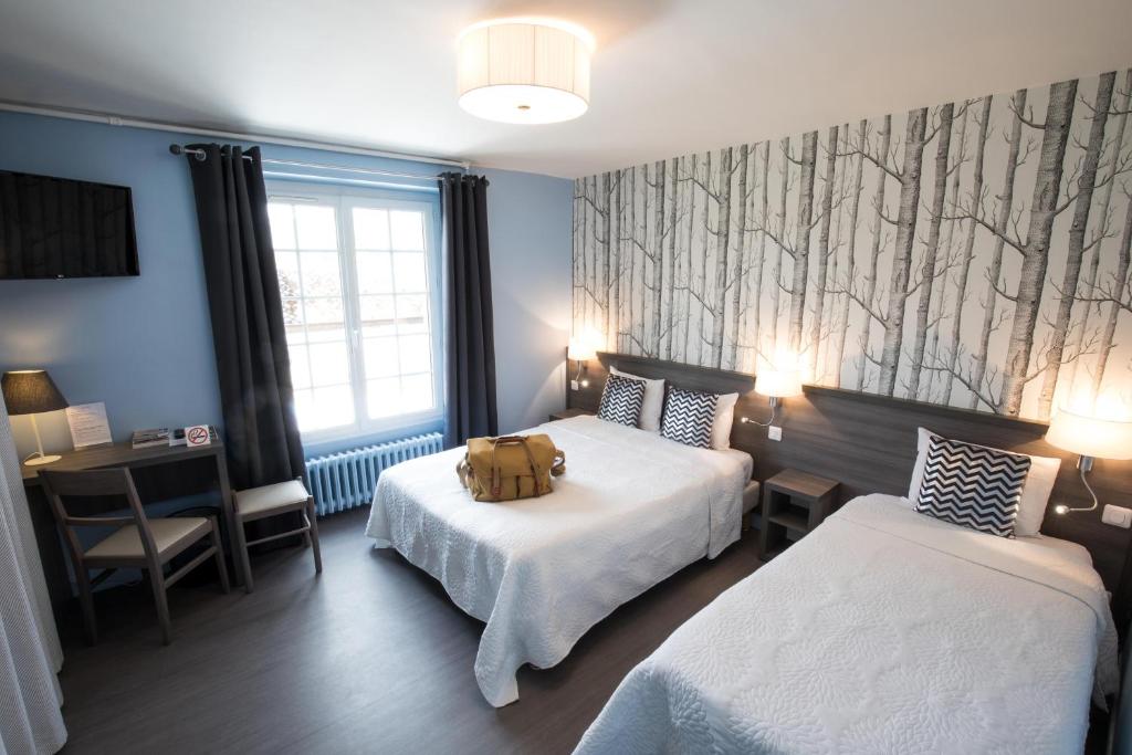 ein Hotelzimmer mit 2 Betten und einem Teddybär auf dem Bett in der Unterkunft Logis Hôtel Restaurant de la Poste in Le Mêle-sur-Sarthe