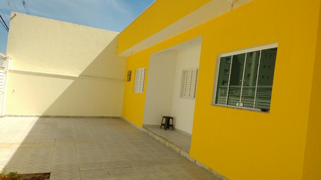 a yellow and white building with a window at Quartos com Banheiros privativos - Hospedagem Recanto do Luar in Taubaté