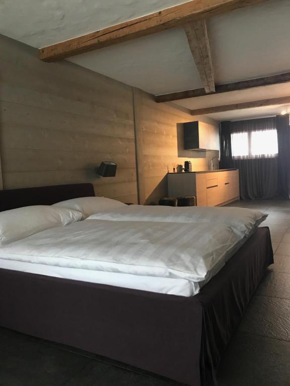 グスタードにあるCharly Studio In Gstaadのベッドルーム(白いシーツを使用した大型ベッド1台付)