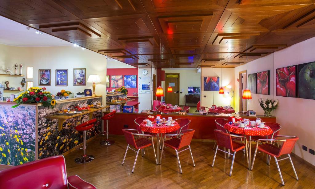 米拉佐的住宿－太陽繫住宿加早餐旅館，一间餐厅,房间内设有红色的椅子和桌子