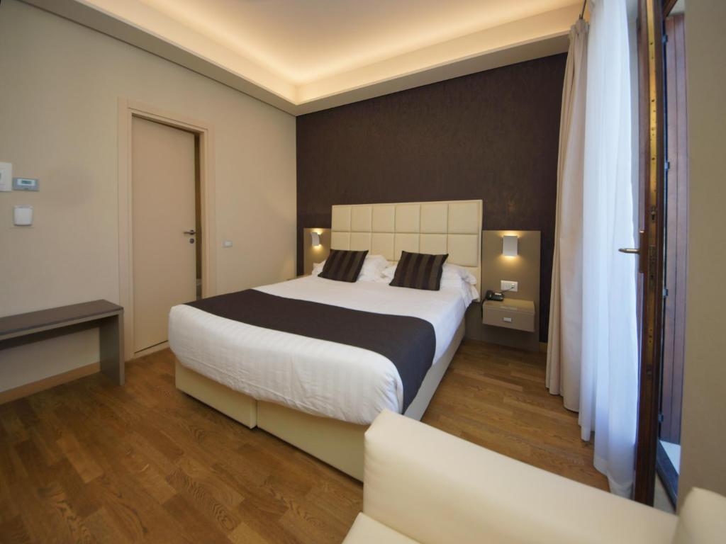 a hotel room with a bed and a chair at Hotel Dori in Peschiera del Garda