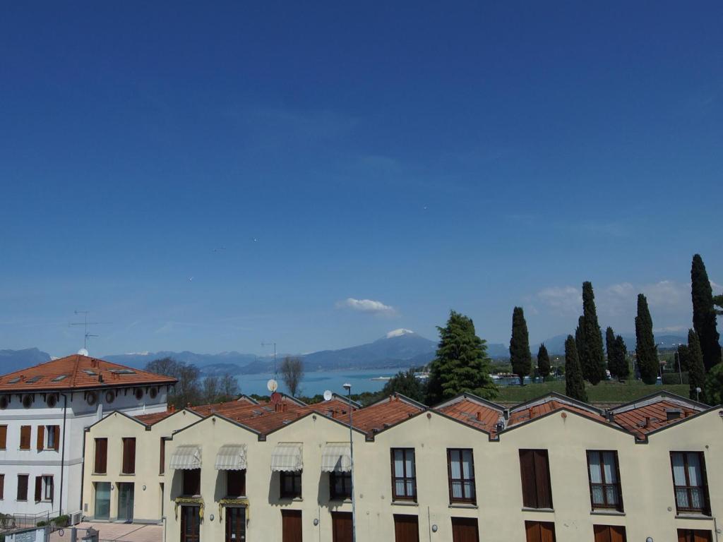 a large white building with red tile roofs at Hotel Dori in Peschiera del Garda