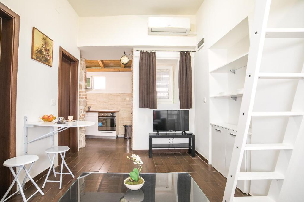 a living room with a staircase and a tv at Midtown Center Apartments in Zadar