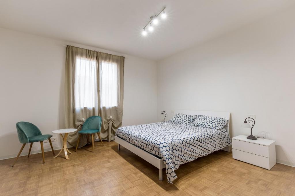 sypialnia z łóżkiem, stołem i krzesłami w obiekcie CaMagnolia Apartment w mieście Montegrotto Terme