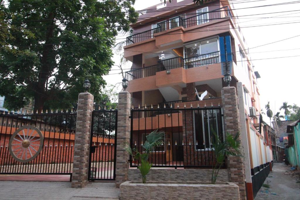 un edificio con una puerta de hierro forjado y una valla en Little Rangpur Inn, en Rangpur