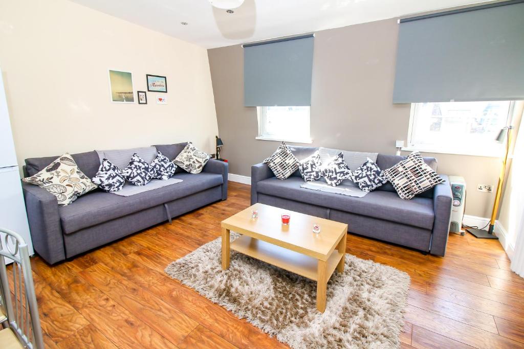 Sala de estar con 2 sofás y mesa de centro en City view flat @ Liverpool st., en Londres