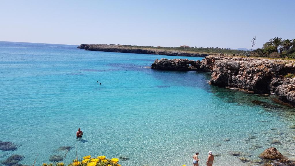 un grupo de personas de pie en el agua en una playa en Cala Morlanda en S'Illot