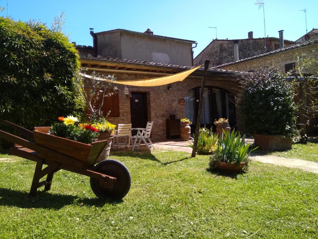 un jardin avec une brouette fleurie dans l'établissement Antiche Dimore Vescovado, à Murlo