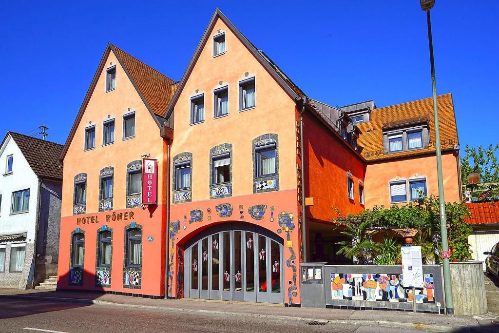 a large orange building with a gate in front of it at Hotel Römer in Günzburg