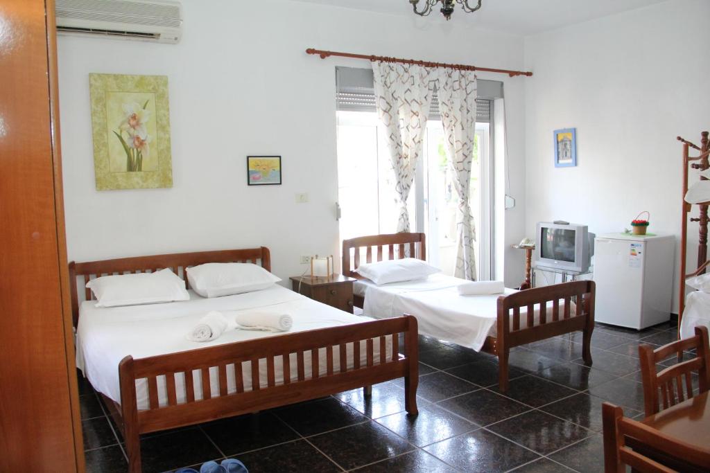 1 dormitorio con 2 camas y 2 sillas en Hotel Italia, en Tirana