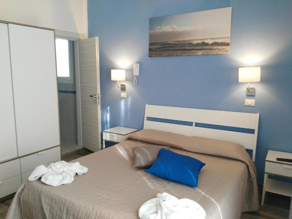 una camera da letto con un letto e due asciugamani di Hotel Marittimo a Rimini