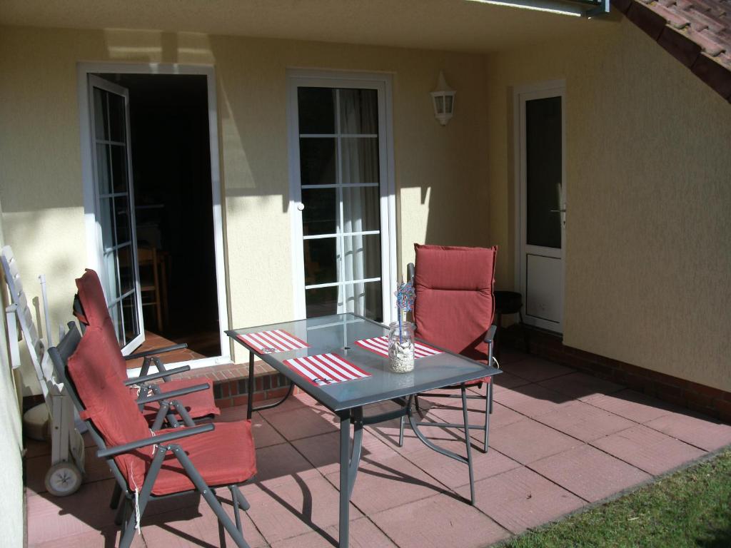 une table et des chaises assises sur une terrasse dans l'établissement Gartenstraße 40d, à Karlshagen
