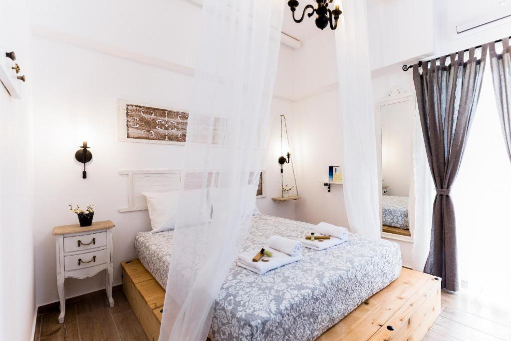 una camera da letto con pareti bianche e un letto con lenzuola bianche di EvaEle Luxury Apartments a Kíssamos