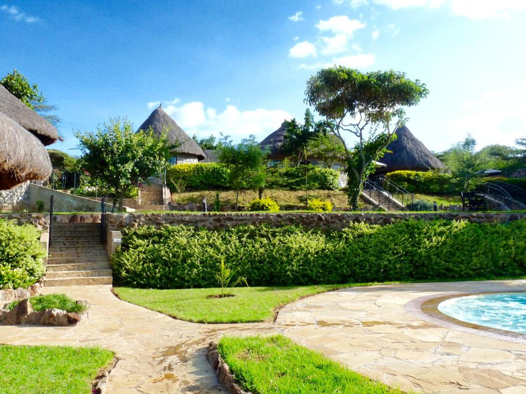 a resort yard with a swimming pool and houses at Nyati Hill Cottages in Nairobi
