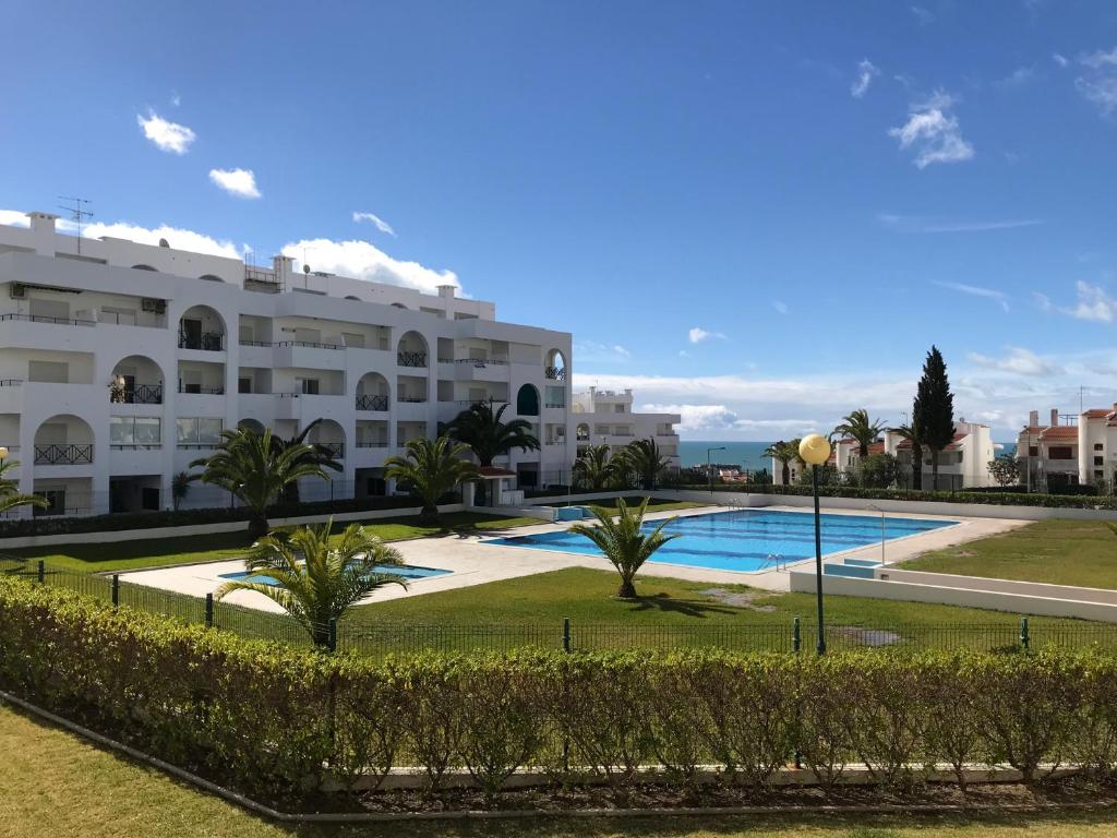 um grande edifício de apartamentos com uma grande piscina em Algarve Armacao de Pera Alporchinhos Appartement Climatise Plage A Pied em Armação de Pêra