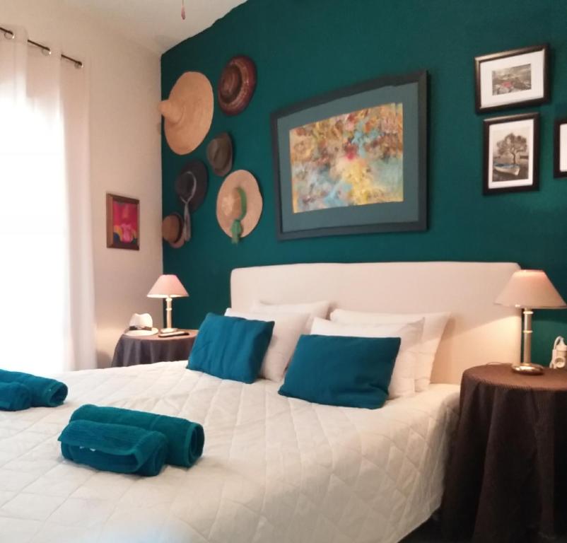 1 dormitorio con 1 cama blanca grande con almohadas azules en Forest & Sea Apartment en Poros