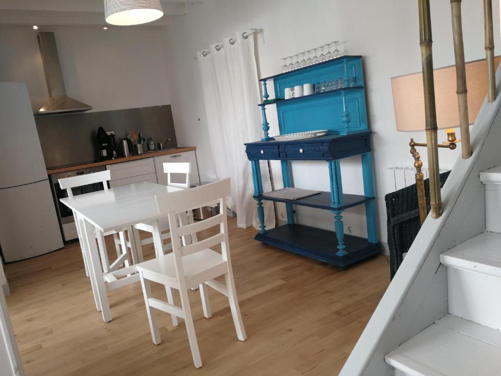 a kitchen with a table and chairs and a blue cabinet at Un jardin sur le toit - Saintes in Saintes