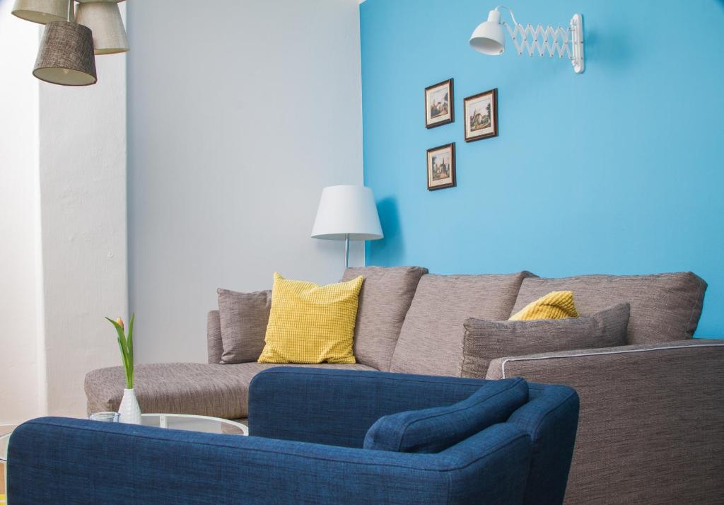 a blue couch in a living room with a blue wall at Stadtbleibe Naumburg in Naumburg