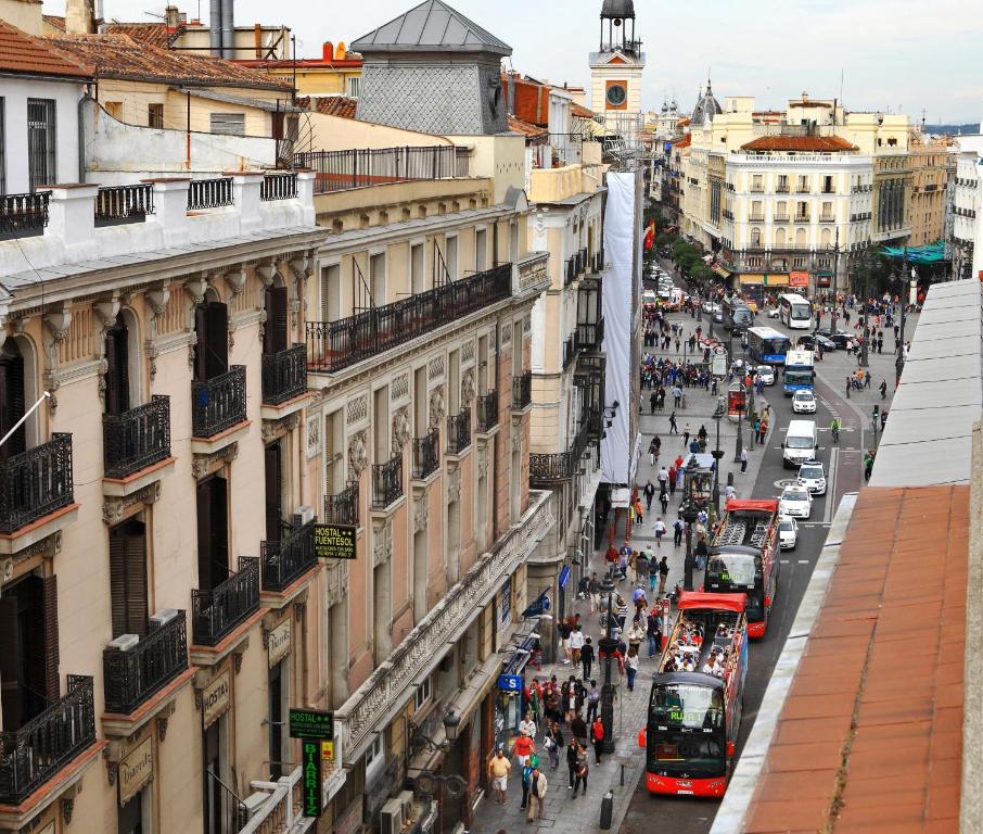 マドリードにあるEstudio Puerta Del Solのバスや歩行者の多い街並み